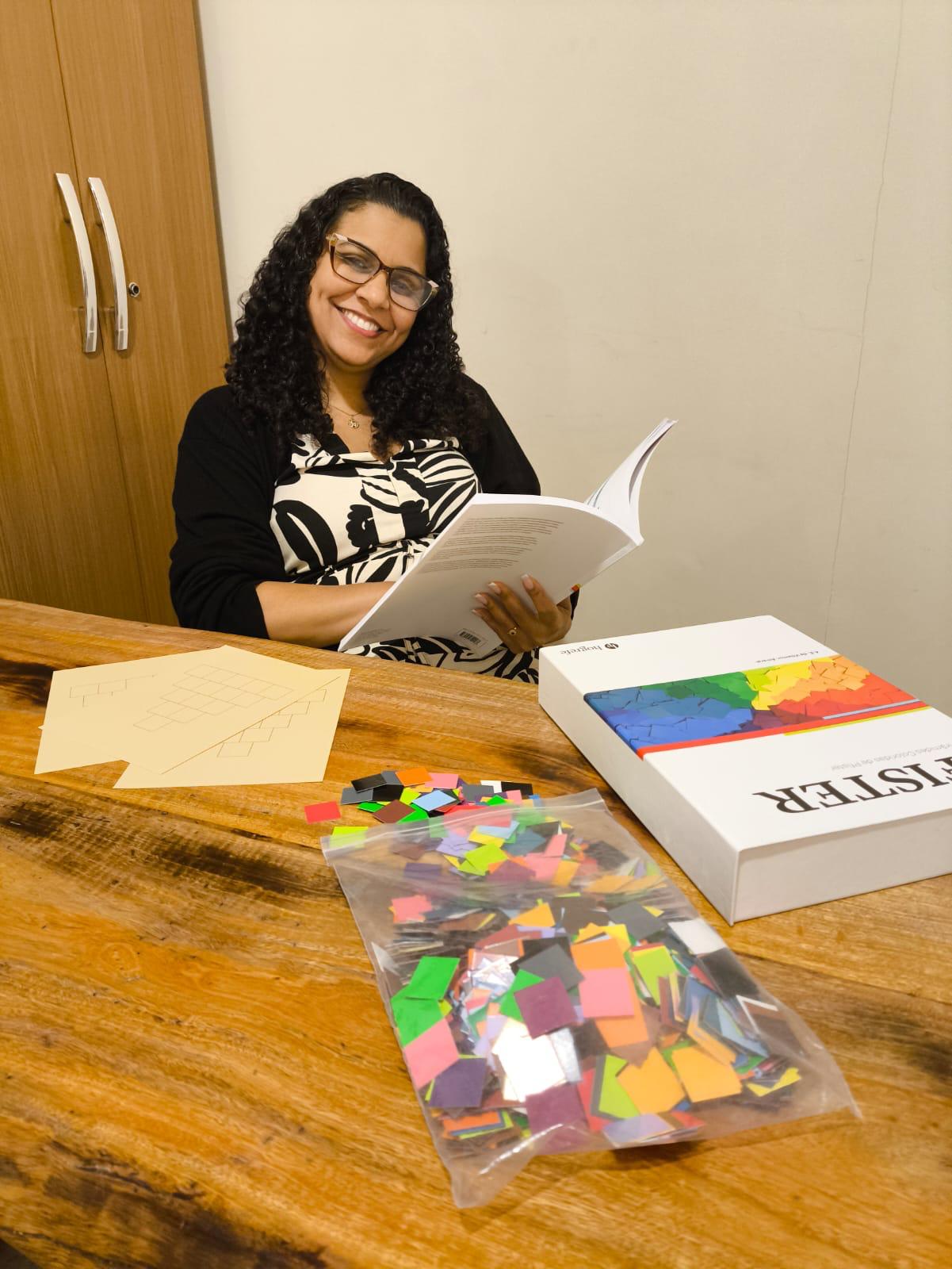 Larissa Bazilio com instrumentos de avaliação neuropsicológica